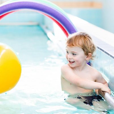 boy swimming with beach ball